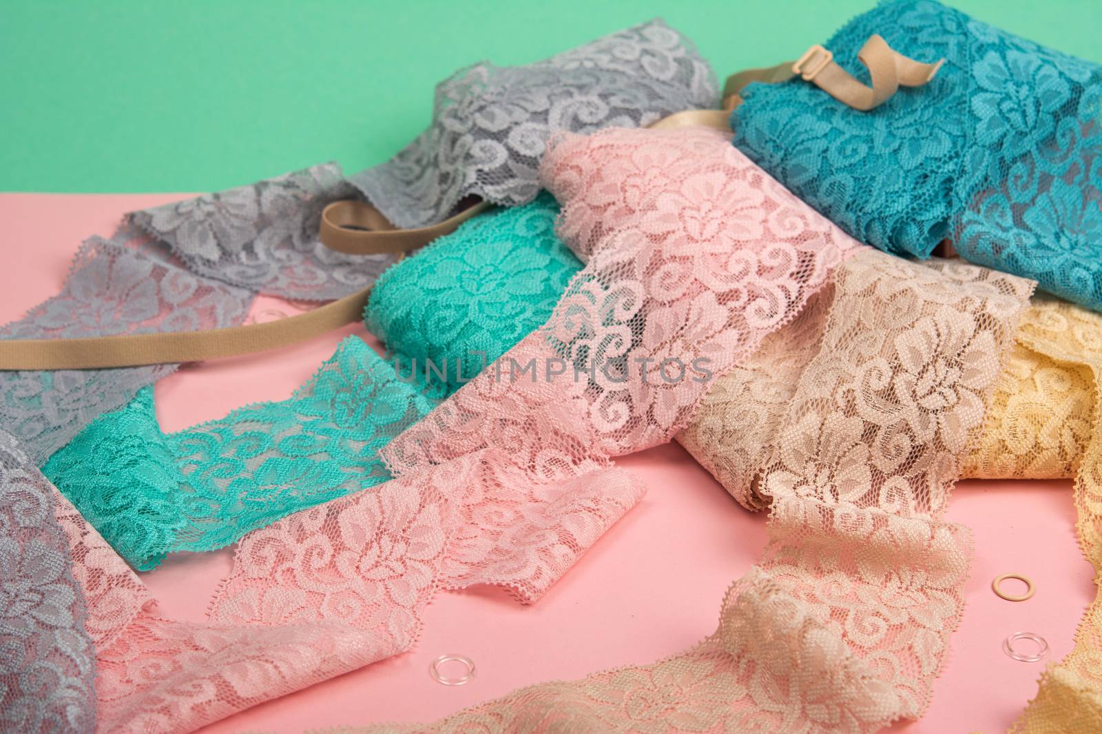 Abstract background with pile of color lace for Lingerie, panties, and bras on pink background. by polyats