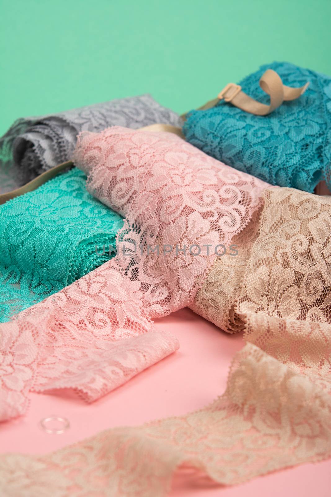 Abstract background with pile of color lace for Lingerie, panties, and bras on pink background. by polyats