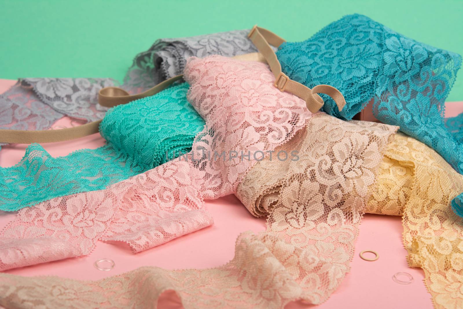 Abstract background with pile of color lace for Lingerie, panties, and bras on pink background. by polyats