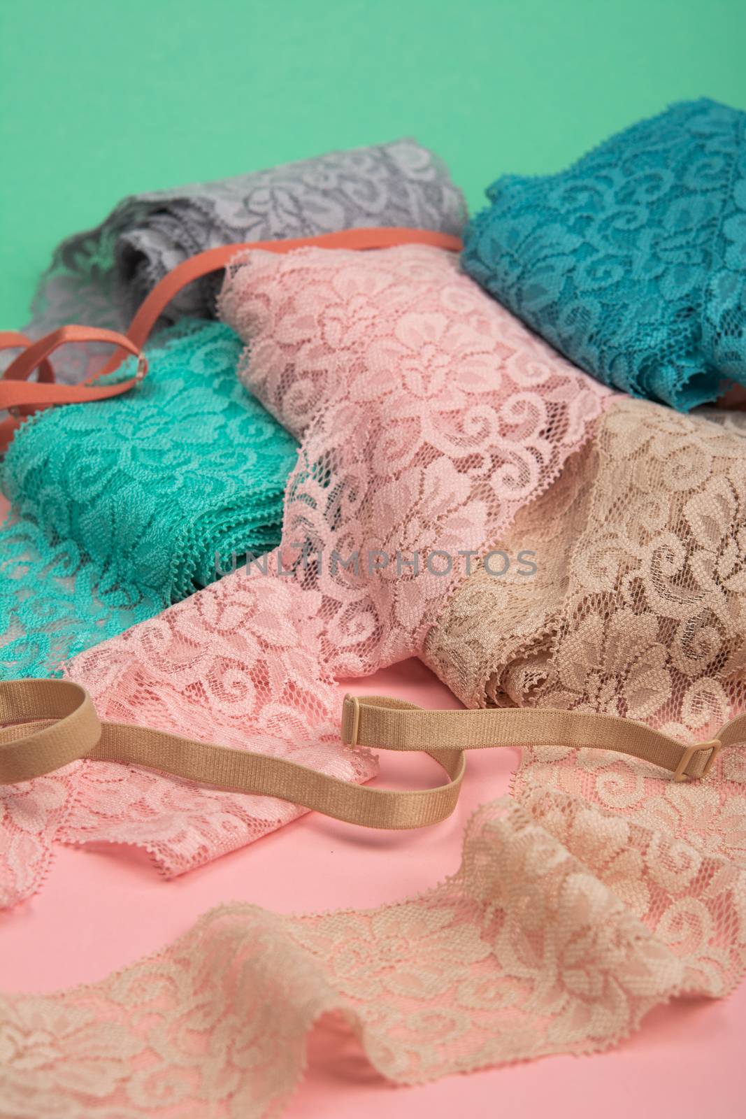 Abstract background with pile of color lace for Lingerie, panties, and bras on pink background. by polyats