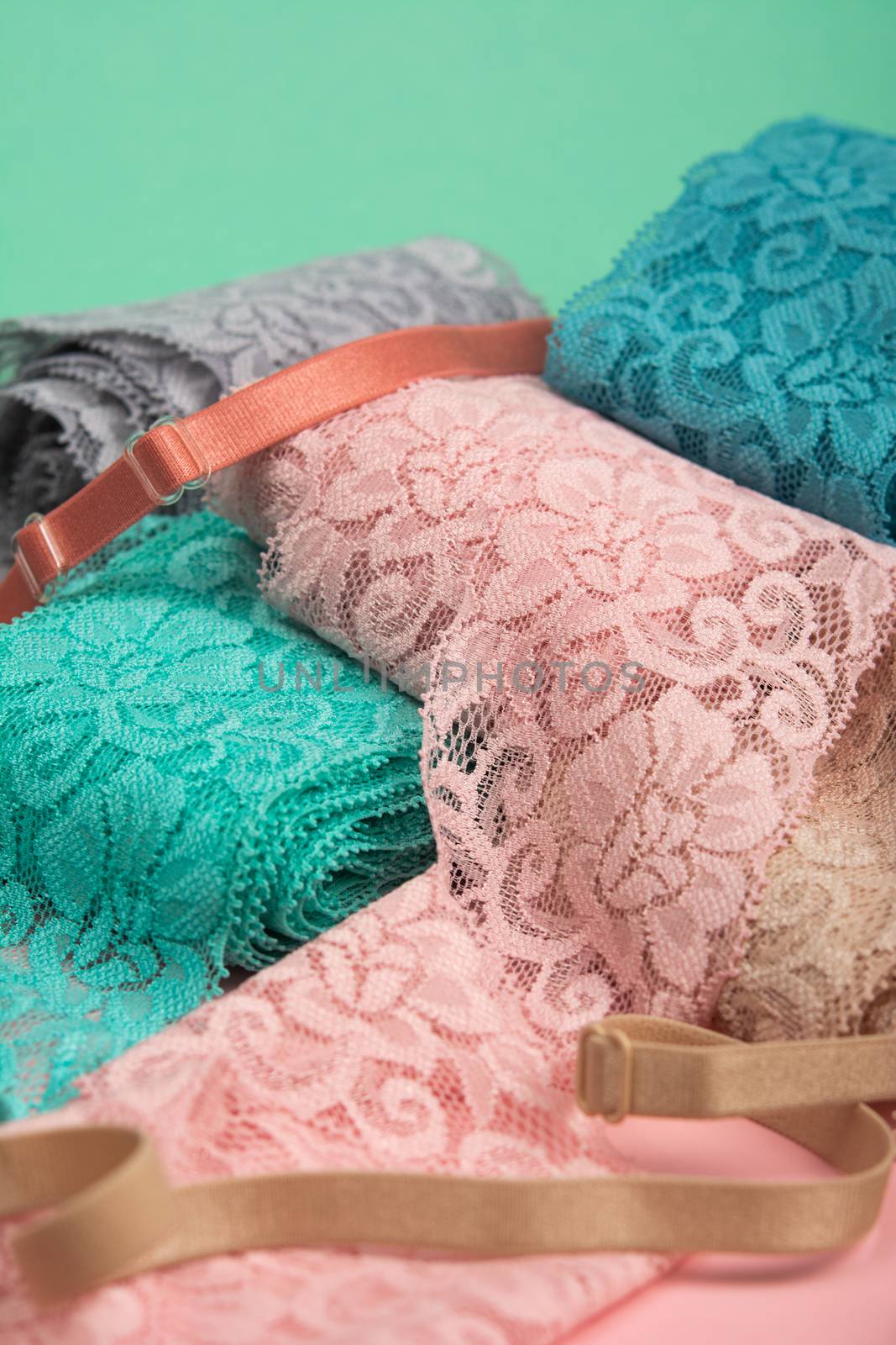 Abstract background with pile of color lace for Lingerie, panties, and bras on pink background. by polyats