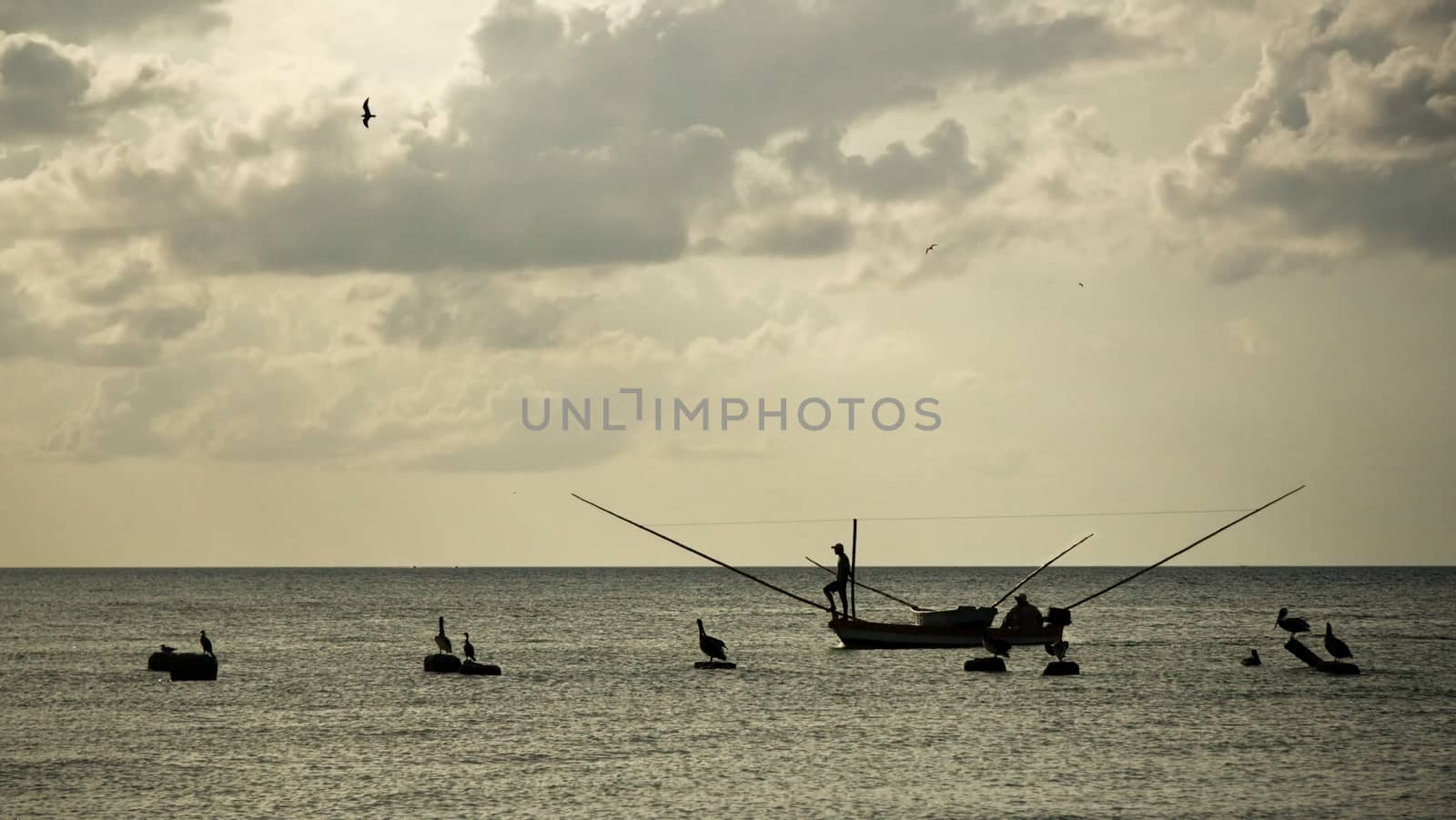 Silhouettes of fisherman on small fishing boat, with neotropic c by Ivanko