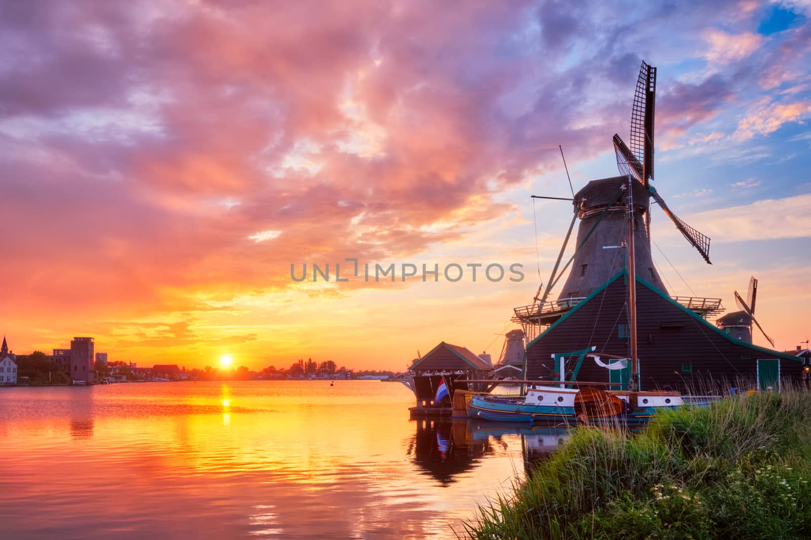 Netherlands rural scene - - windmills at famous tourist site Zaanse Schans in Holland on sunset with dramatic sky. Zaandam, Netherlands