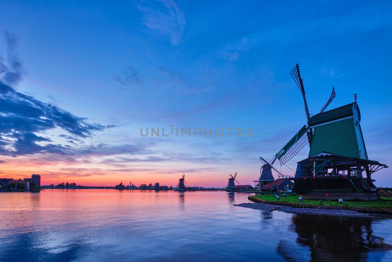 Windmills at famous tourist site Zaanse Schans in Holland with dramatic sky. Zaandam, Netherlands by dimol