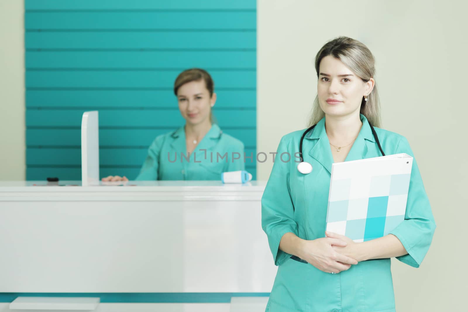 Two female doctors or nurses looking at the camera. Stethoscope on the neck by selinsmo