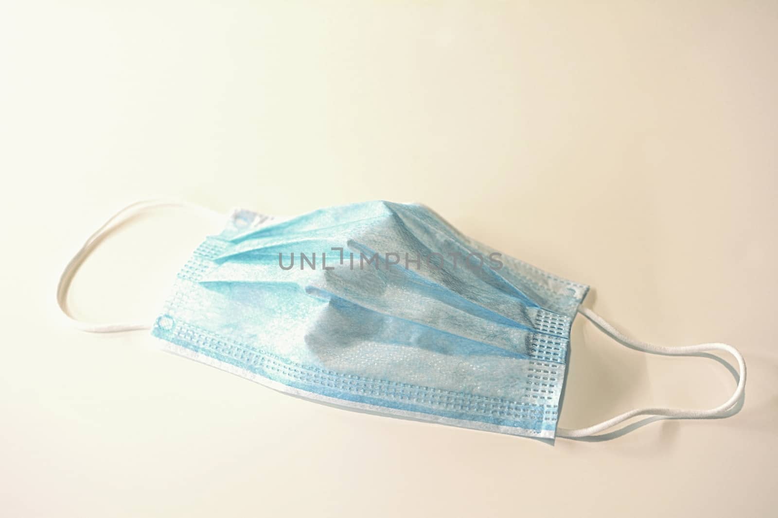 Blue surgical face mask protecting against Coronavirus Covid-19 placed on white background.