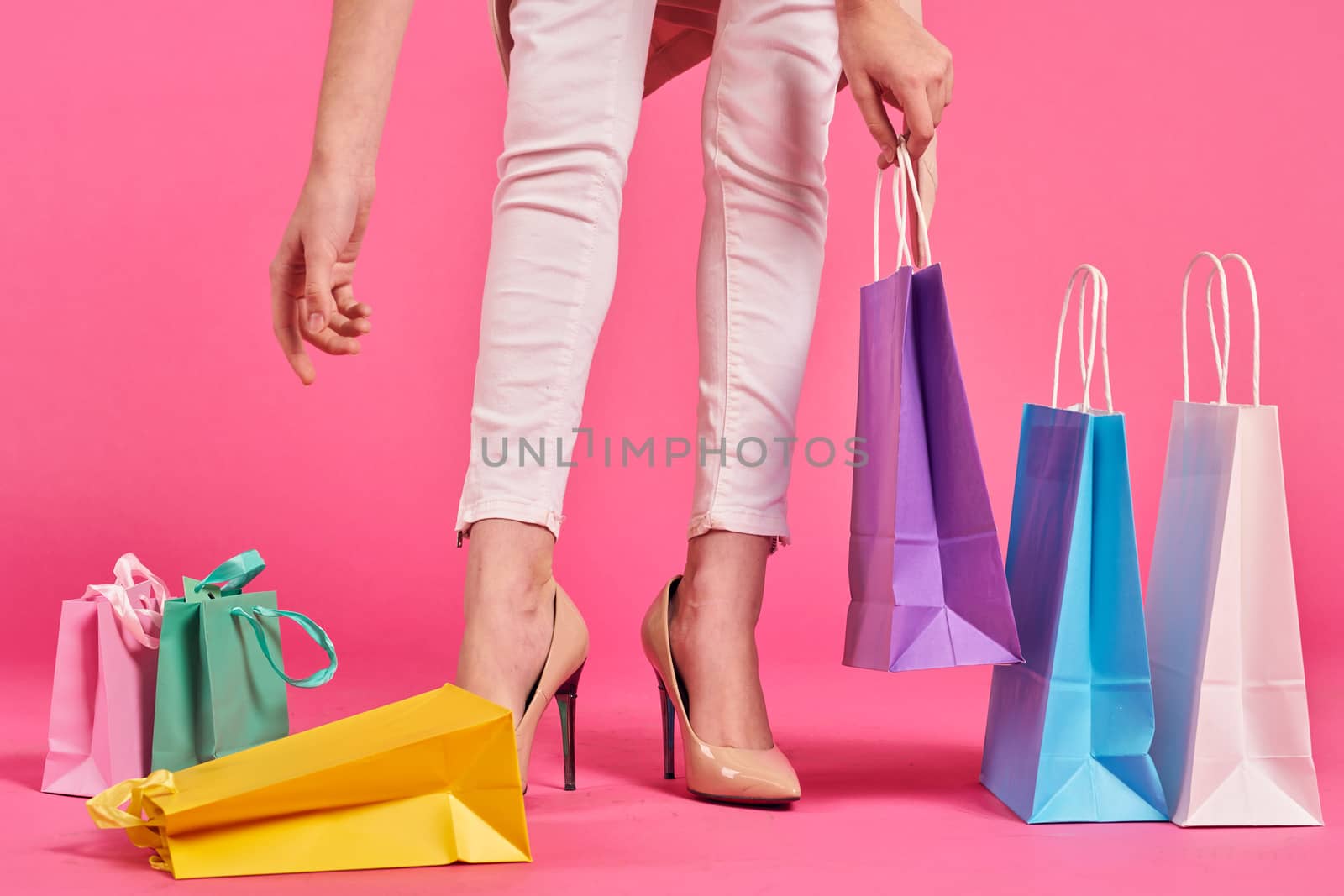 shopping bags female feet in shoes Shopaholic pink background by SHOTPRIME