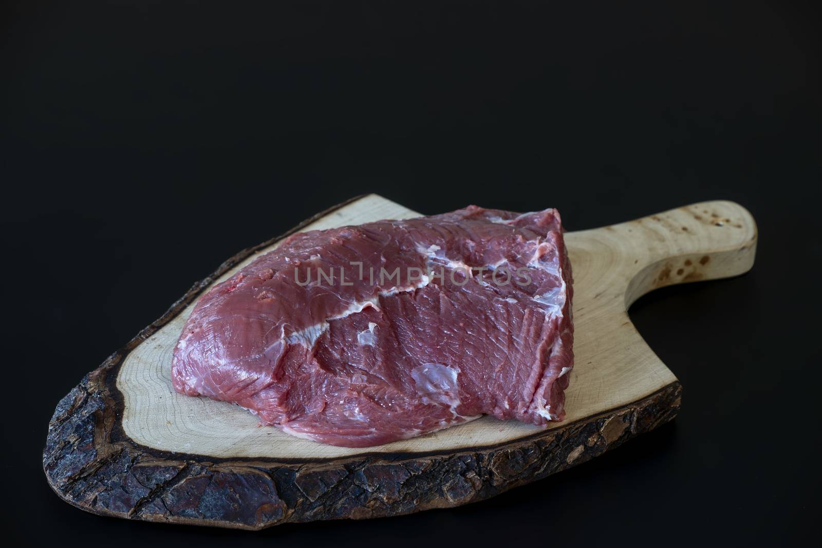 raw meat on wooden chopping board