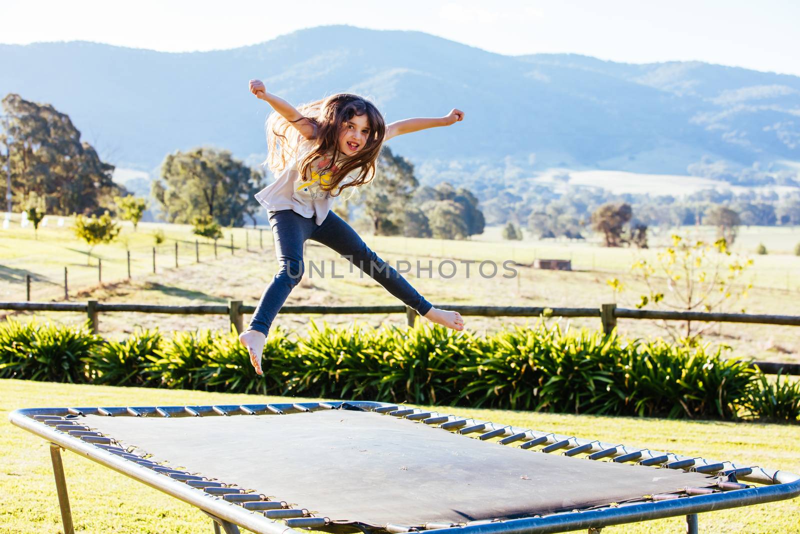 Classic Australian landscape with kids jumping on a trampoline in Victoria Australia