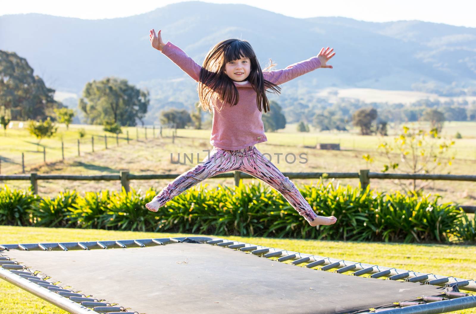 Classic Australian landscape with kids jumping on a trampoline in Victoria Australia