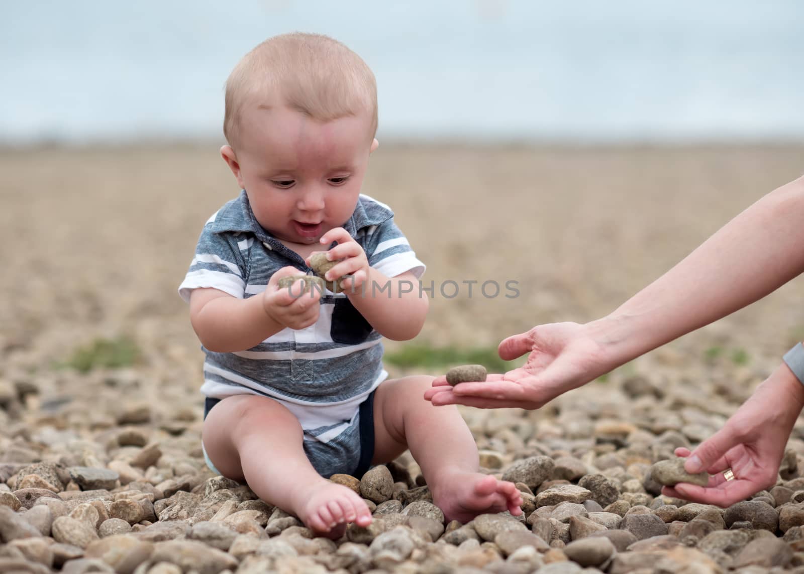 Small boy playing with stones on the seaside