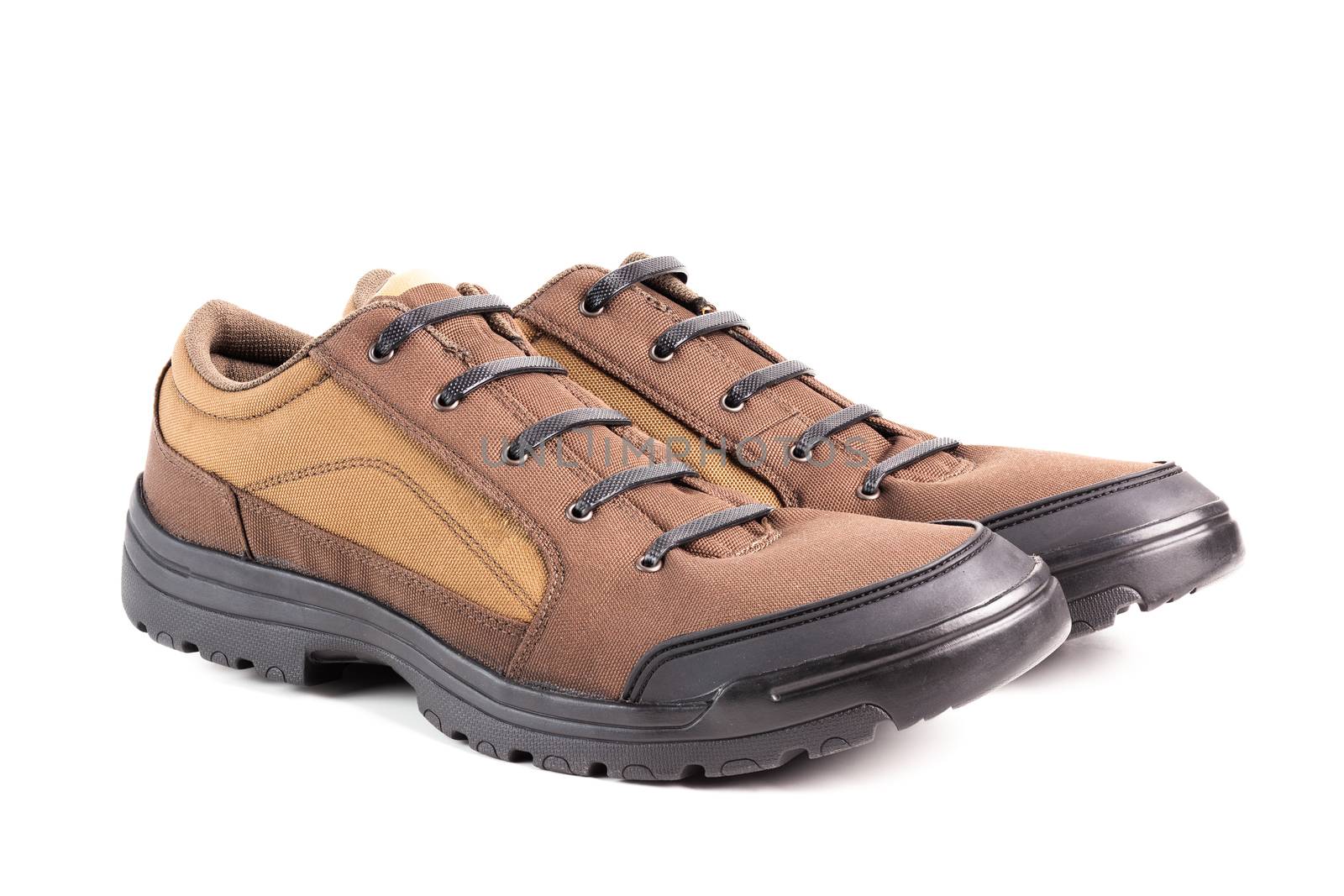 a pair of cheap brown fabric hiking or hunting shoes with elastic rubber laces isolated on white background.