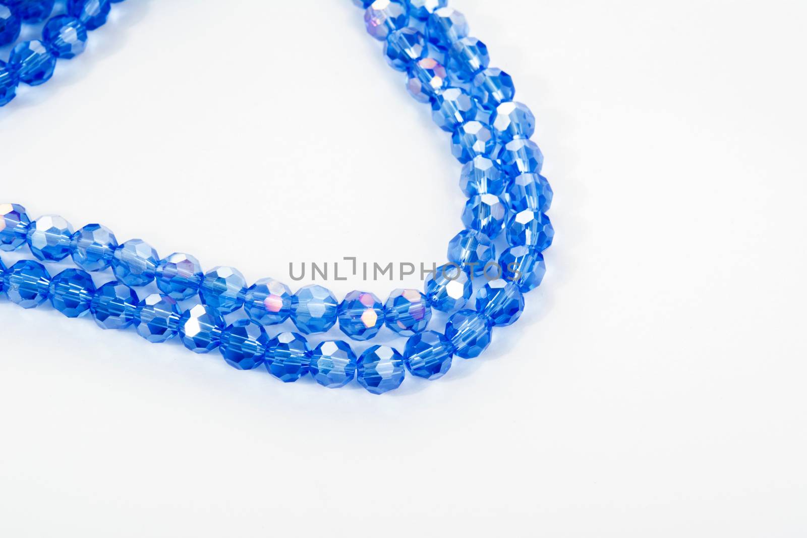 Beautiful blue Glass Sparkle Crystal Isoalted Beads on white background. Use for diy beaded jewelry. Space for text