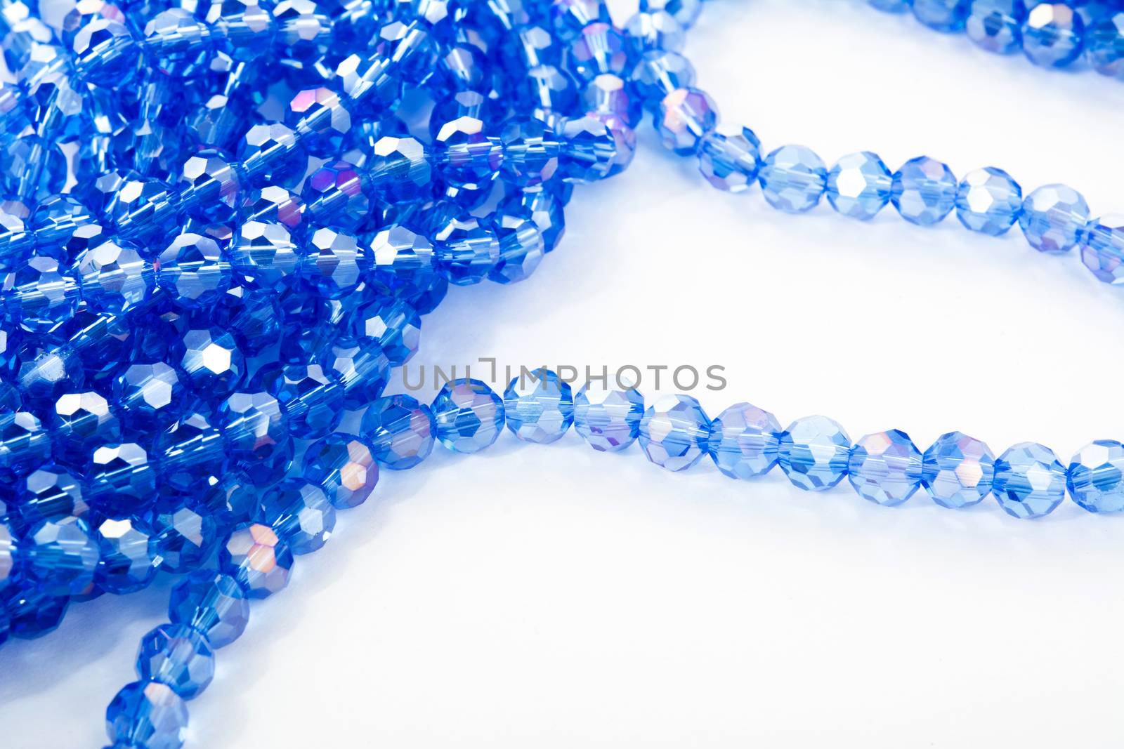 Beautiful blue Glass Sparkle Crystal Isoalted Beads on white background. Use for diy beaded jewelry. Space for text
