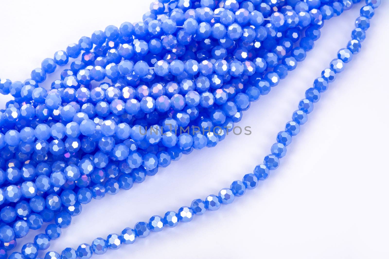 Beautiful blue Glass Sparkle Crystal Isoalted Beads on white background. Use for diy beaded jewelry. Space for text