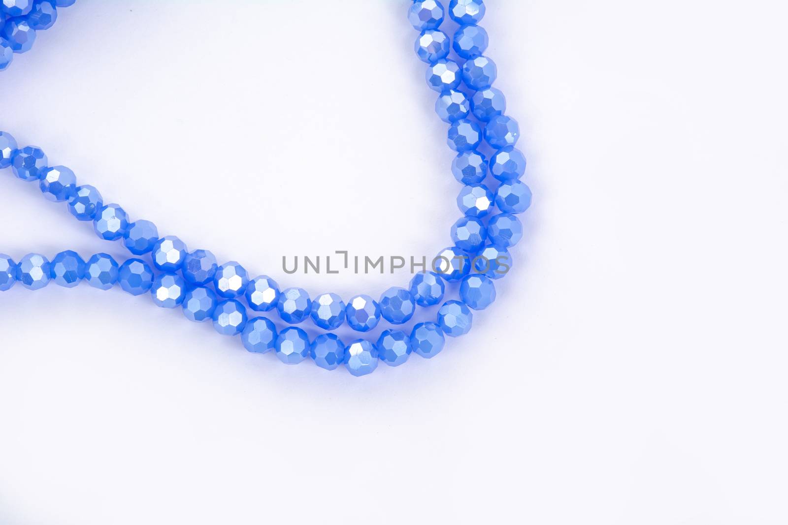 Beautiful blue Glass Sparkle Crystal Isoalted Beads on white background. Use for diy beaded jewelry. Space for text