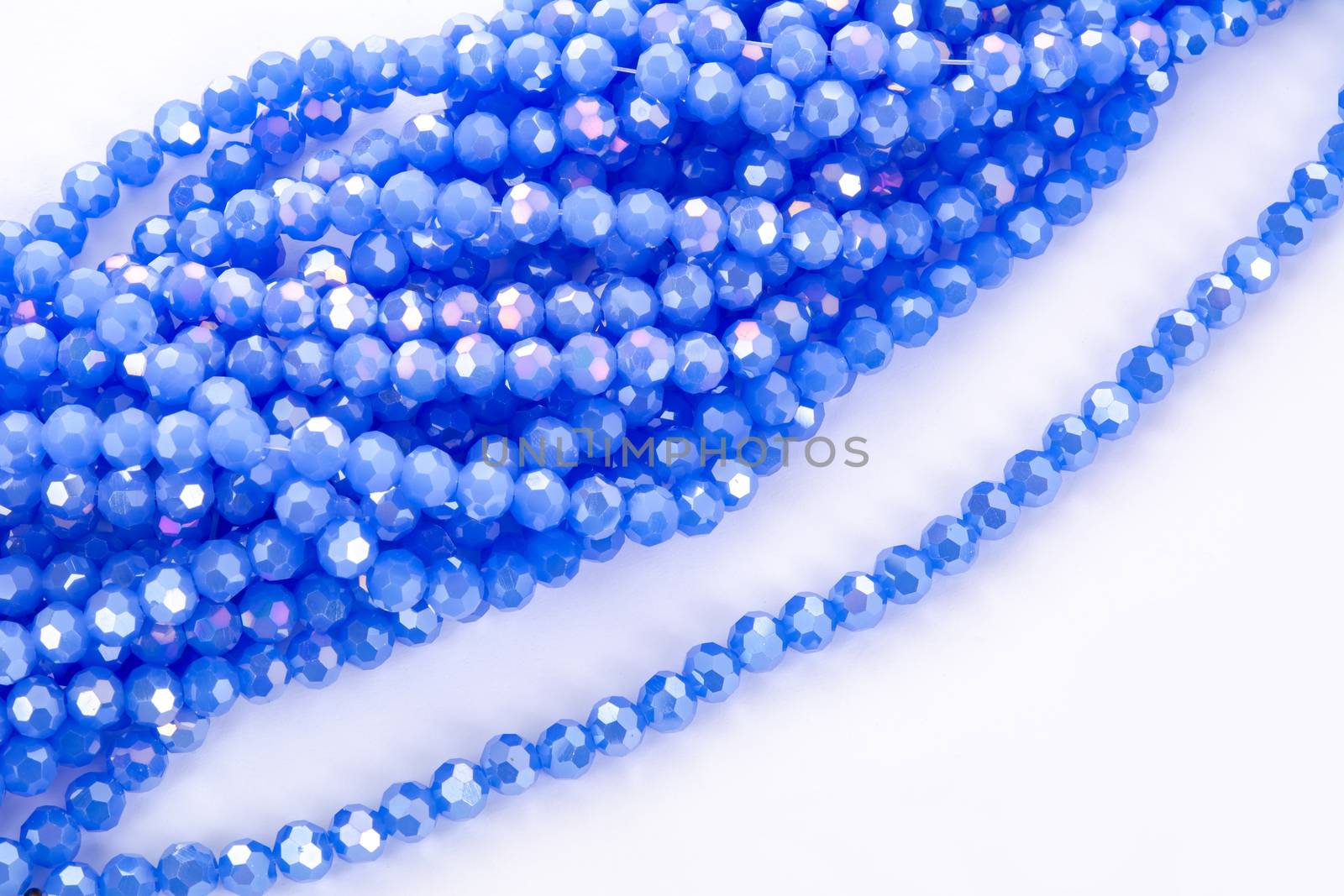 Beautiful blue Glass Sparkle Crystal Isoalted Beads on white background. Use for diy beaded jewelry. Space for text