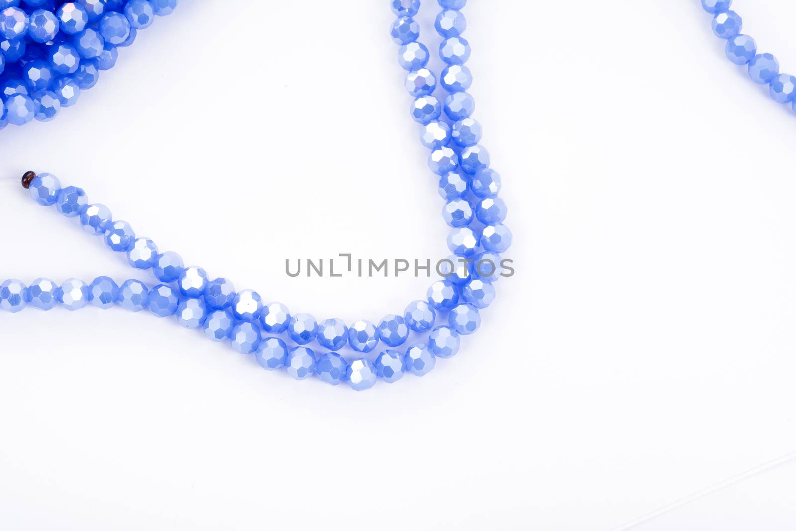 Beautiful blue Glass Sparkle Crystal Isoalted Beads on white background. Use for diy beaded jewelry. Space for text