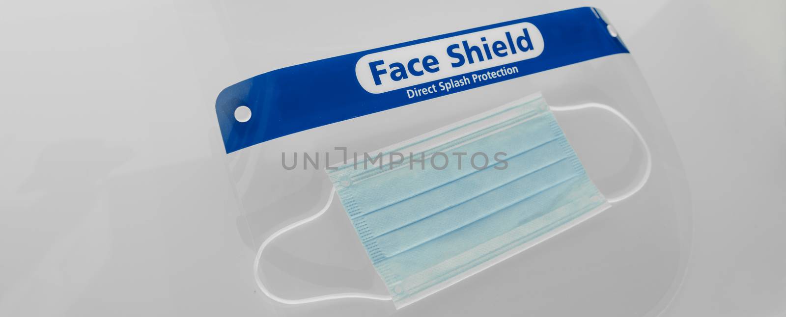 PPE for covid and corona virus. Medical mask and face shield protective equipment for healthcare workers and business. Panoramic banner crop of face covering protection.