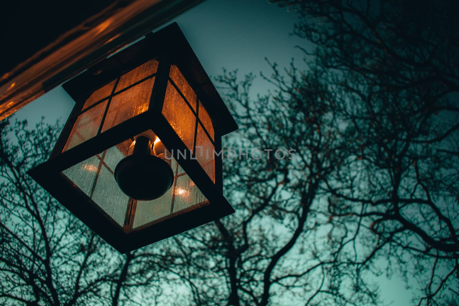 An Old-Fashioned Lamp Hanging on the Side of a Home by bju12290