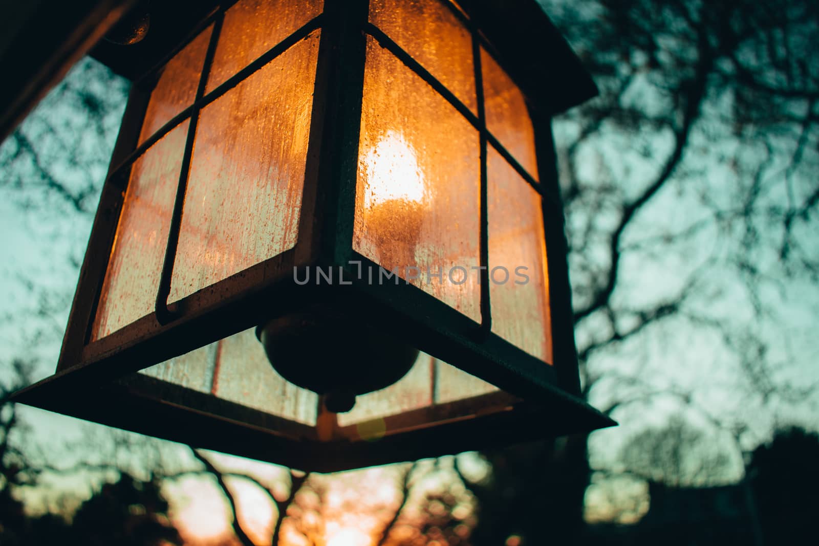 An Old-Fashioned Lamp Hanging on the Side of a Home by bju12290