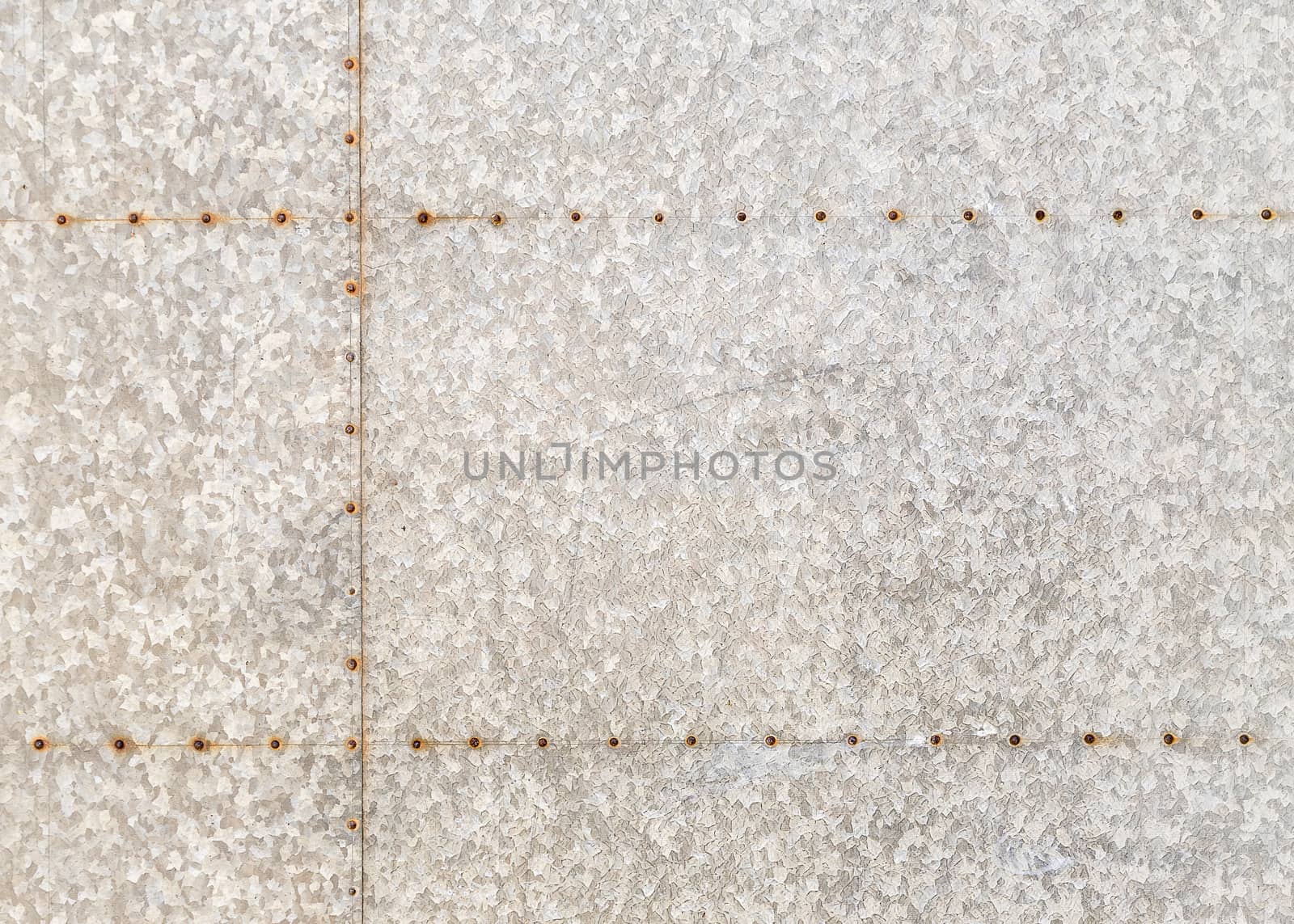 Background of an old marbled metal sheet with rusty rivets.