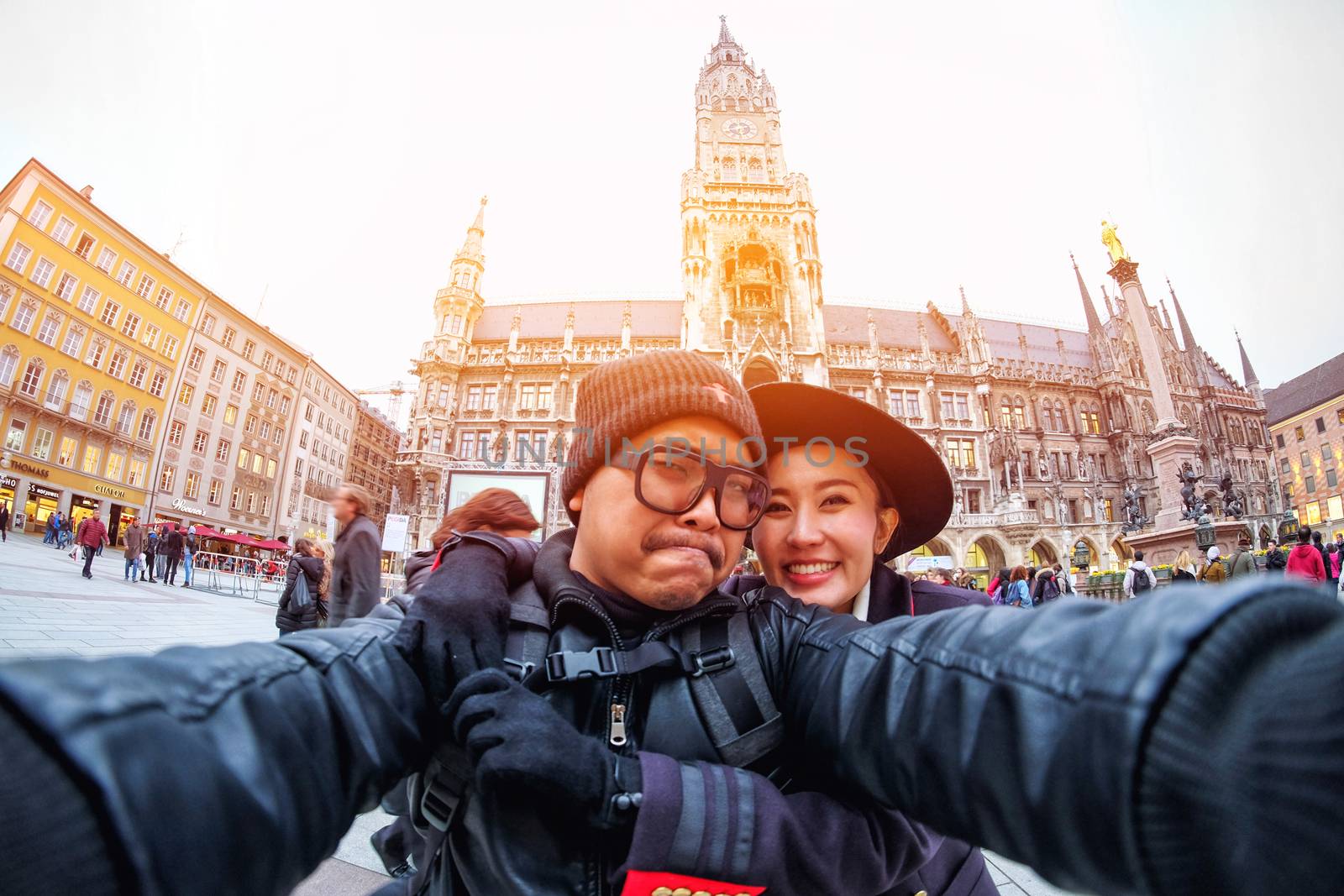 Young Couple Tourists selfie with mobile phone near the  Marienplatz town hall and Frauenkirche in Munich, Germany