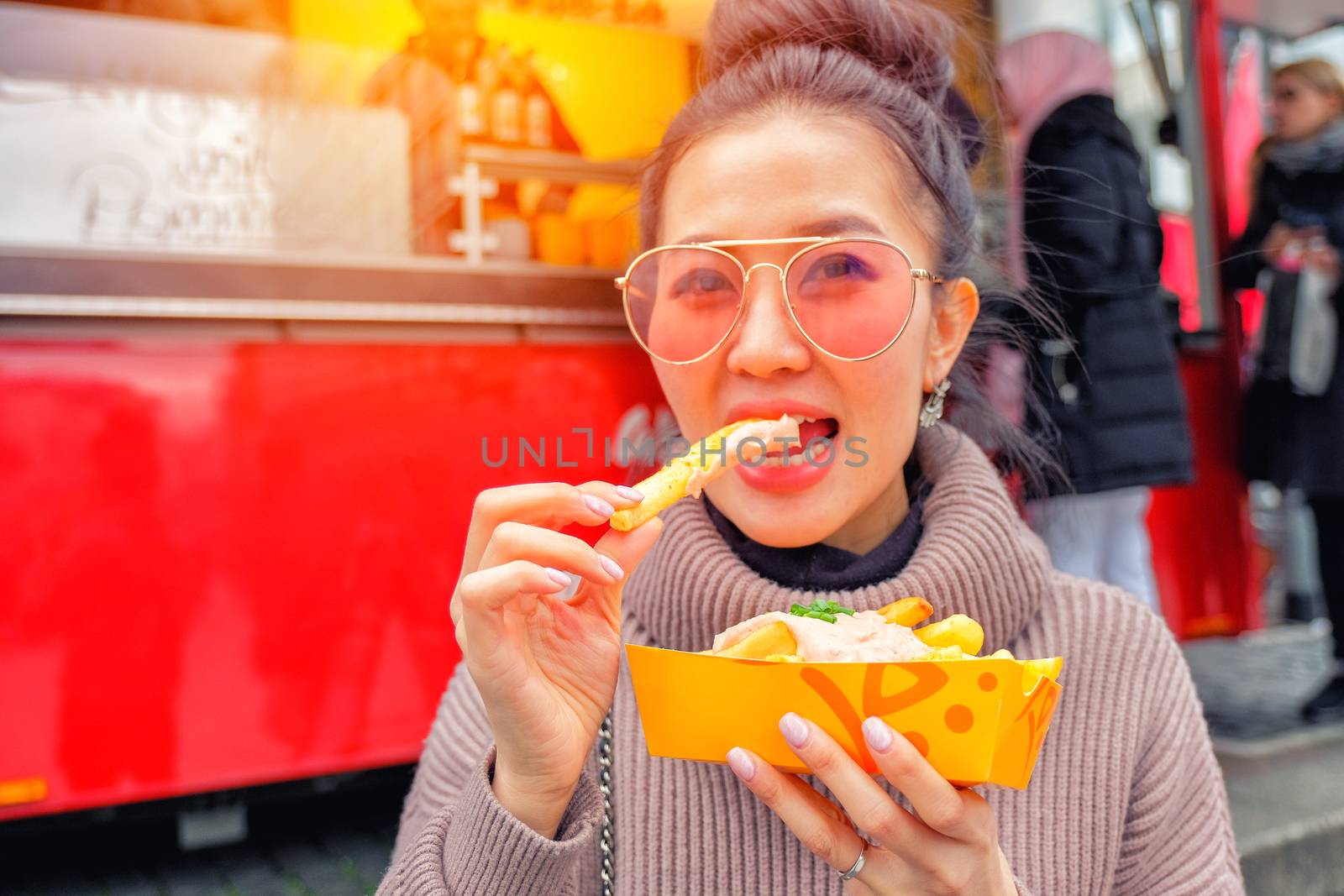Young Woman Eating A  French Fries Street food in Germany