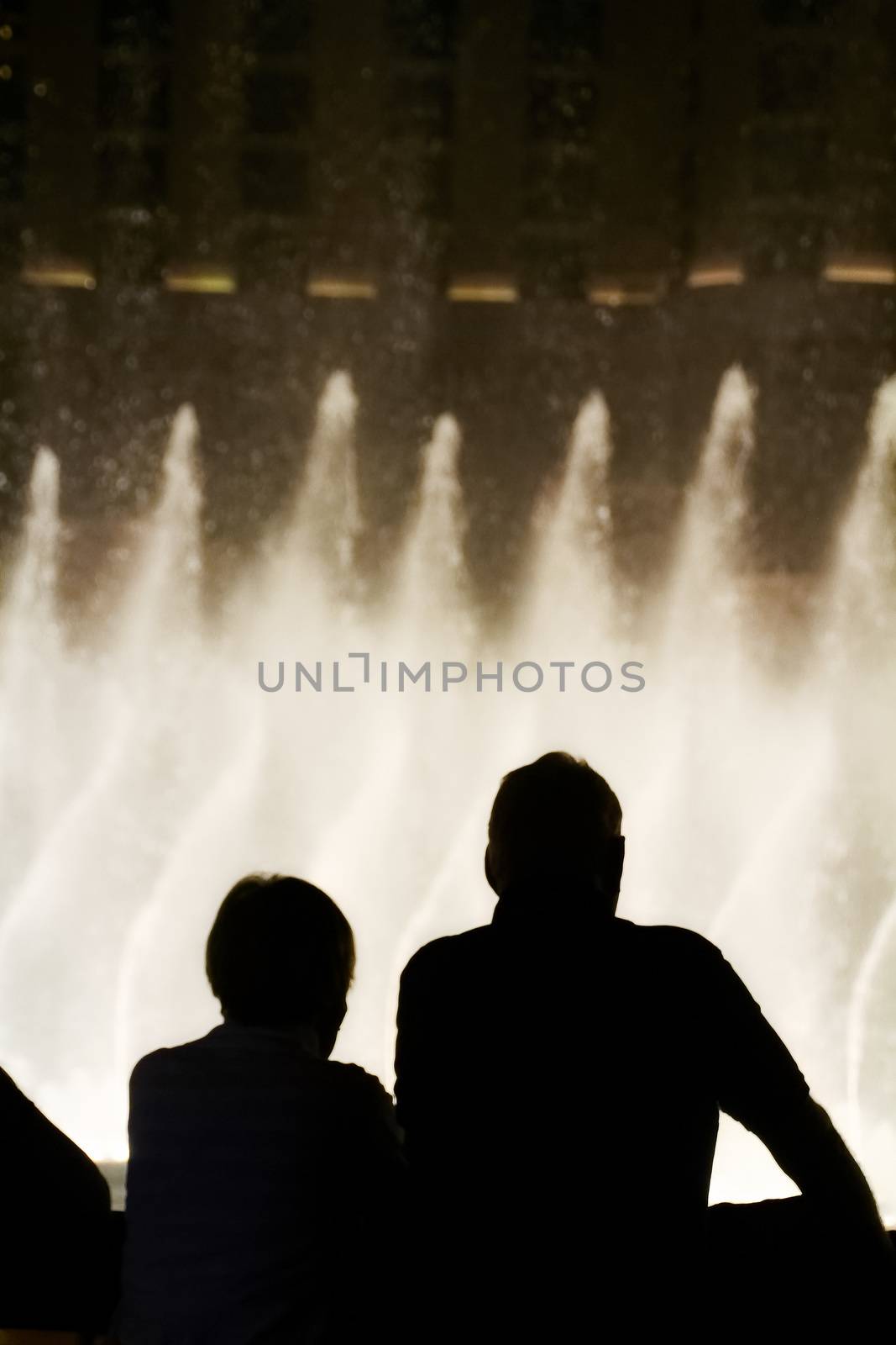 Night scene with silhouettes of people admiring the Bellagio fountains spectacle at Las Vegas by USA-TARO