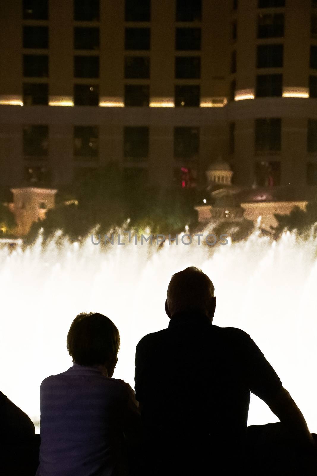 Night scene with silhouettes of people admiring the Bellagio fountains spectacle at Las Vegas by USA-TARO