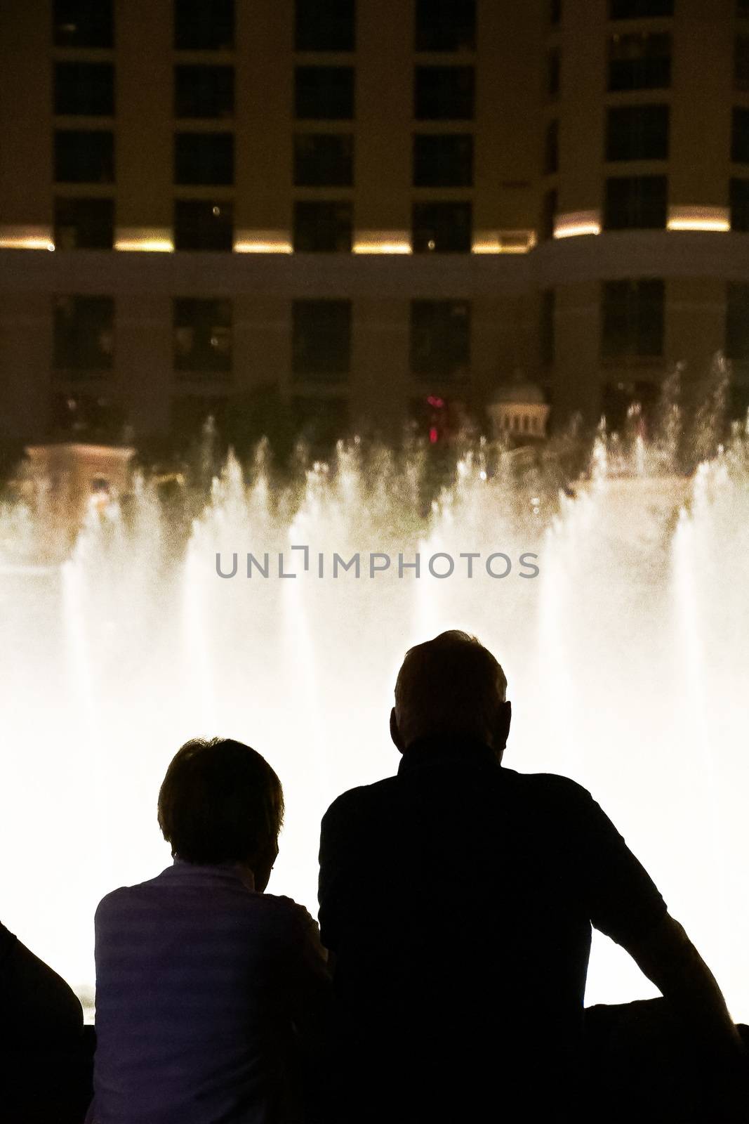 Night scene with silhouettes of people admiring the Bellagio fountains spectacle at Las Vegas by USA-TARO