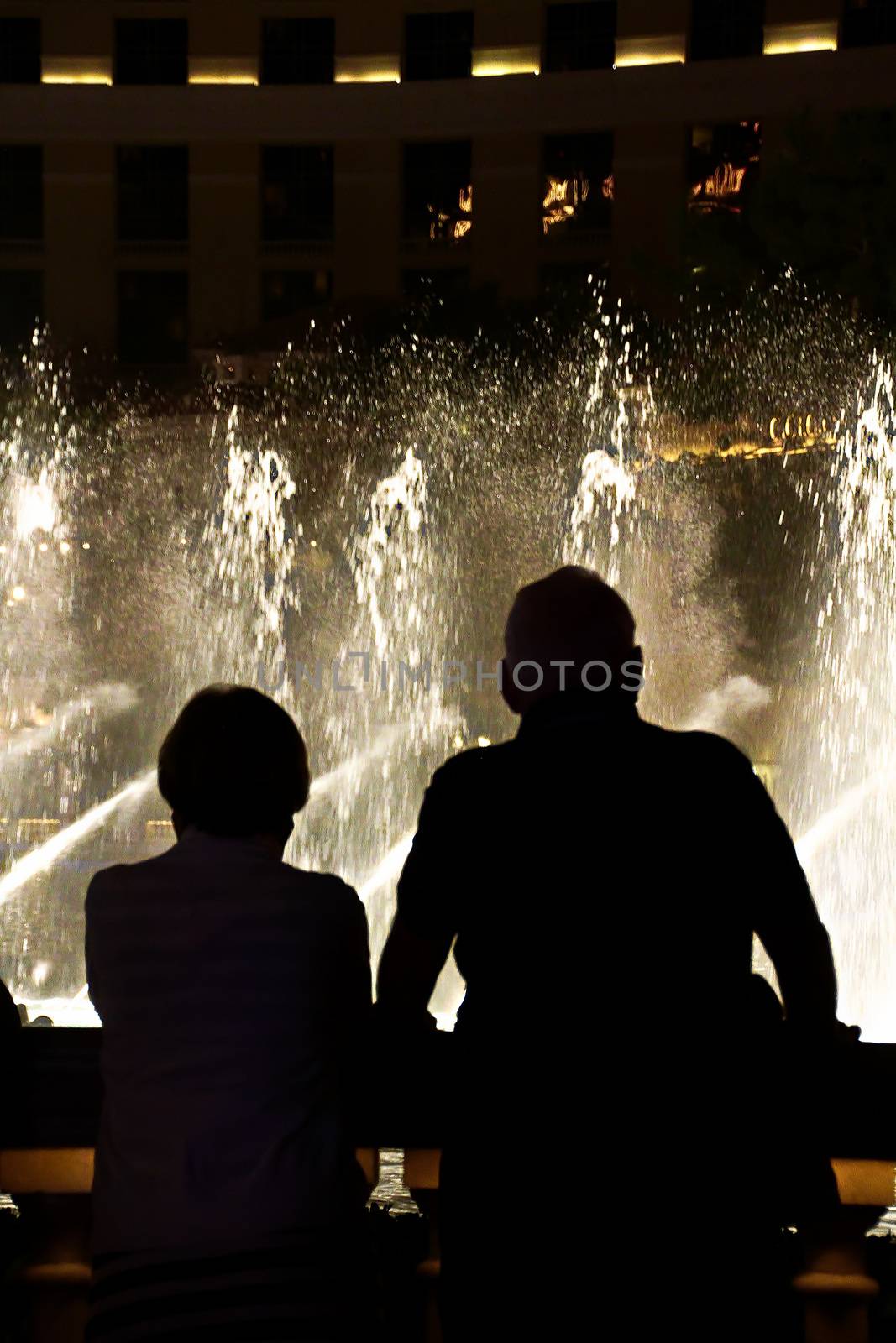 Night scene with silhouettes of people admiring the Bellagio fountains spectacle at Las Vegas by USA-TARO