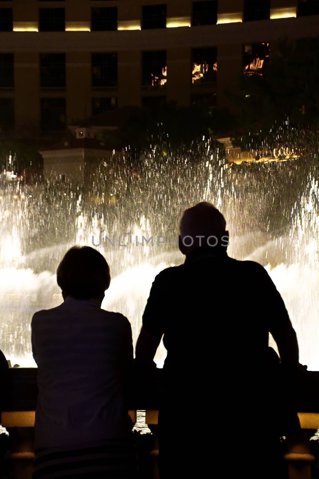 Night scene with silhouettes of people admiring the Bellagio fountains spectacle at Las Vegas by USA-TARO