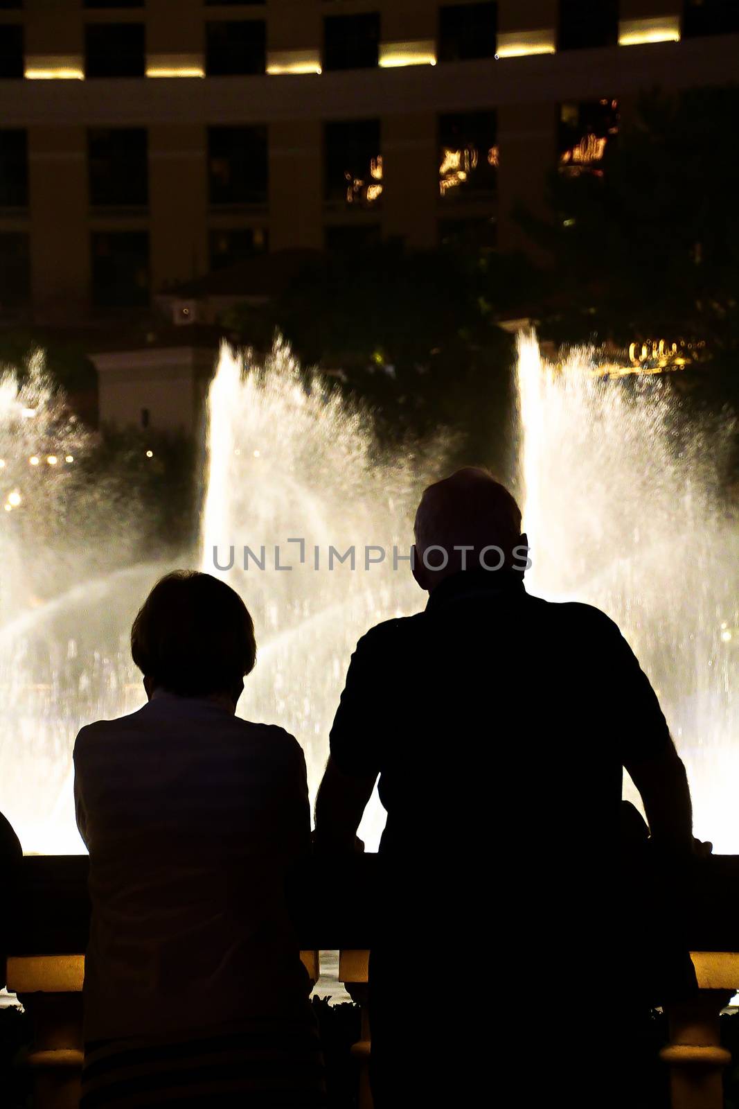 Night scene with silhouettes of people admiring the Bellagio fountains spectacle at Las Vegas by USA-TARO