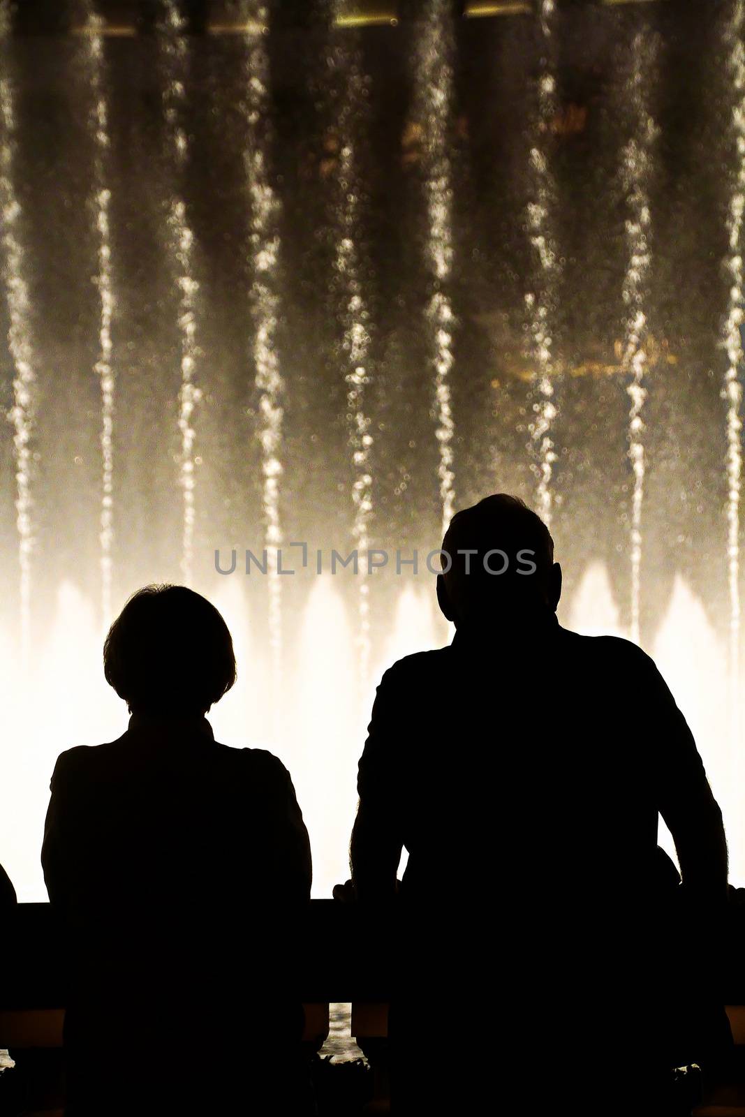 Night scene with silhouettes of people admiring the Bellagio fountains spectacle at Las Vegas by USA-TARO