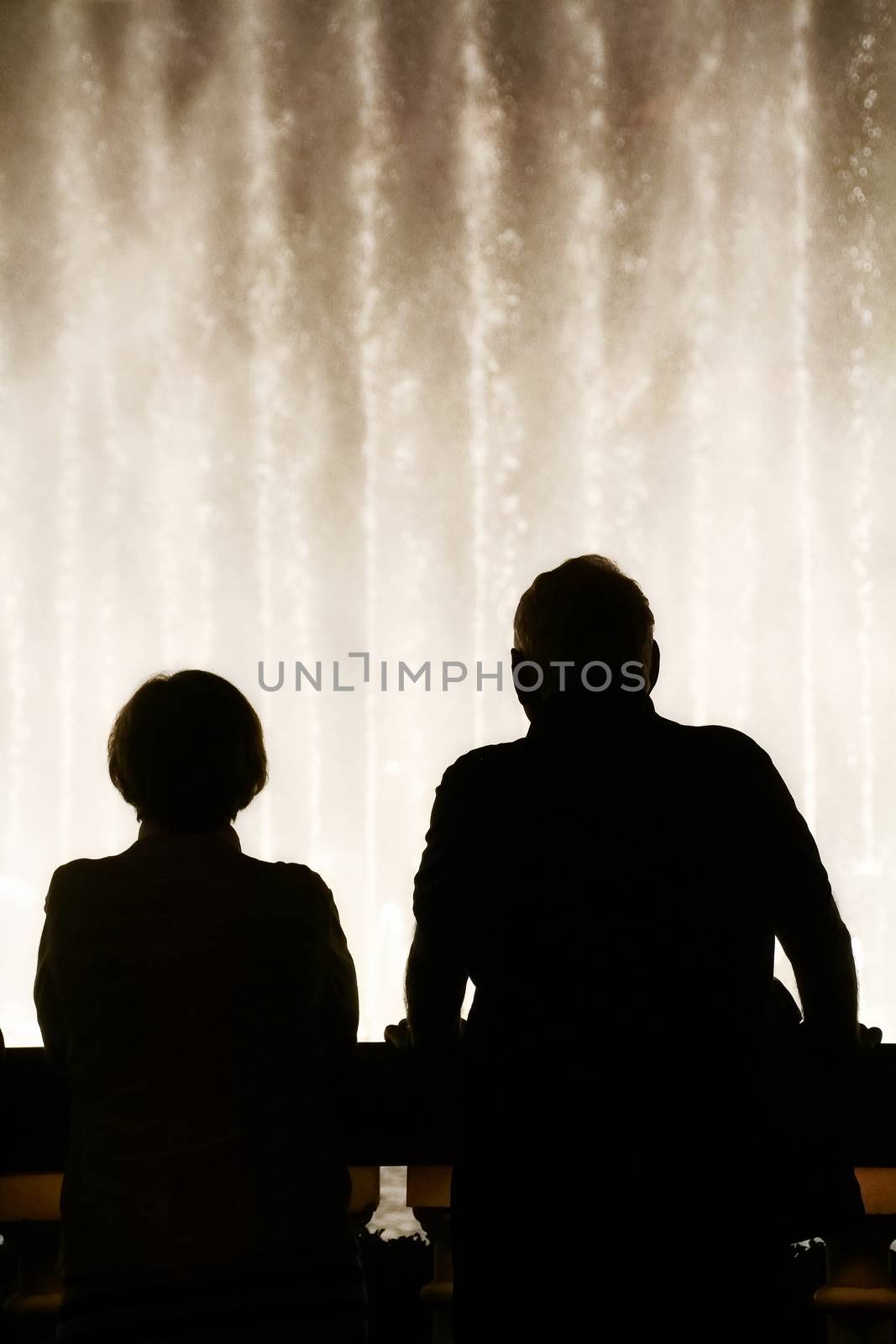 Night scene with silhouettes of people admiring the Bellagio fountains spectacle at Las Vegas