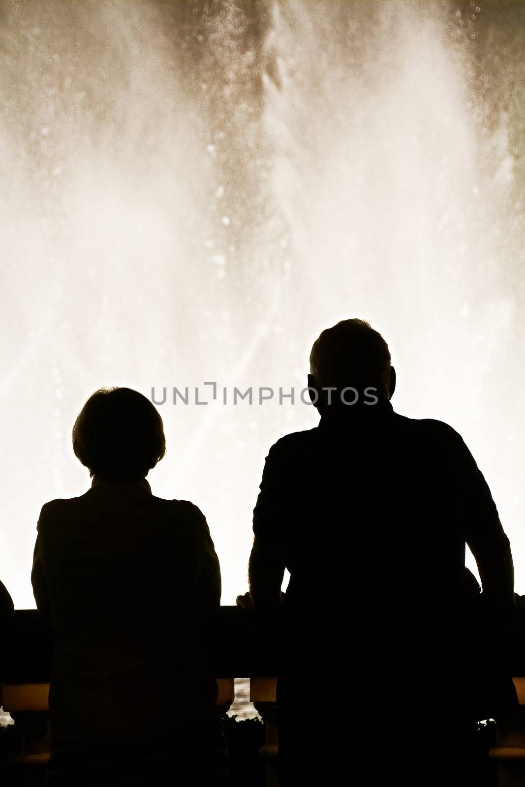 Night scene with silhouettes of people admiring the Bellagio fountains spectacle at Las Vegas