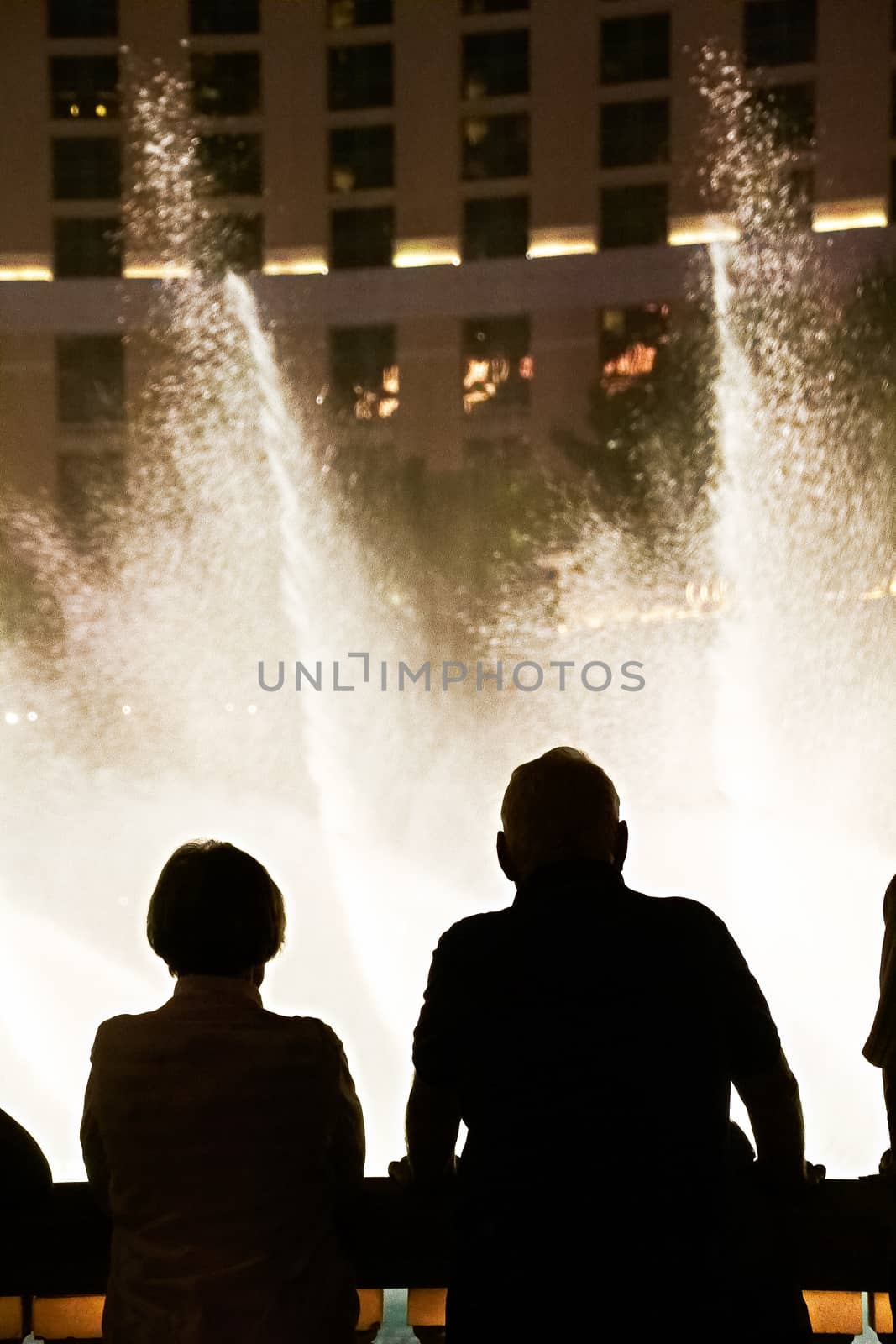 Night scene with silhouettes of people admiring the Bellagio fountains spectacle at Las Vegas by USA-TARO