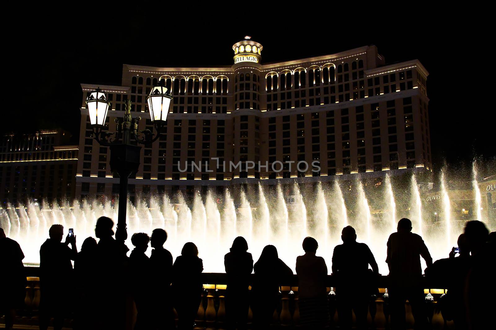 Night scene with silhouettes of people admiring the Bellagio fountains spectacle at Las Vegas by USA-TARO