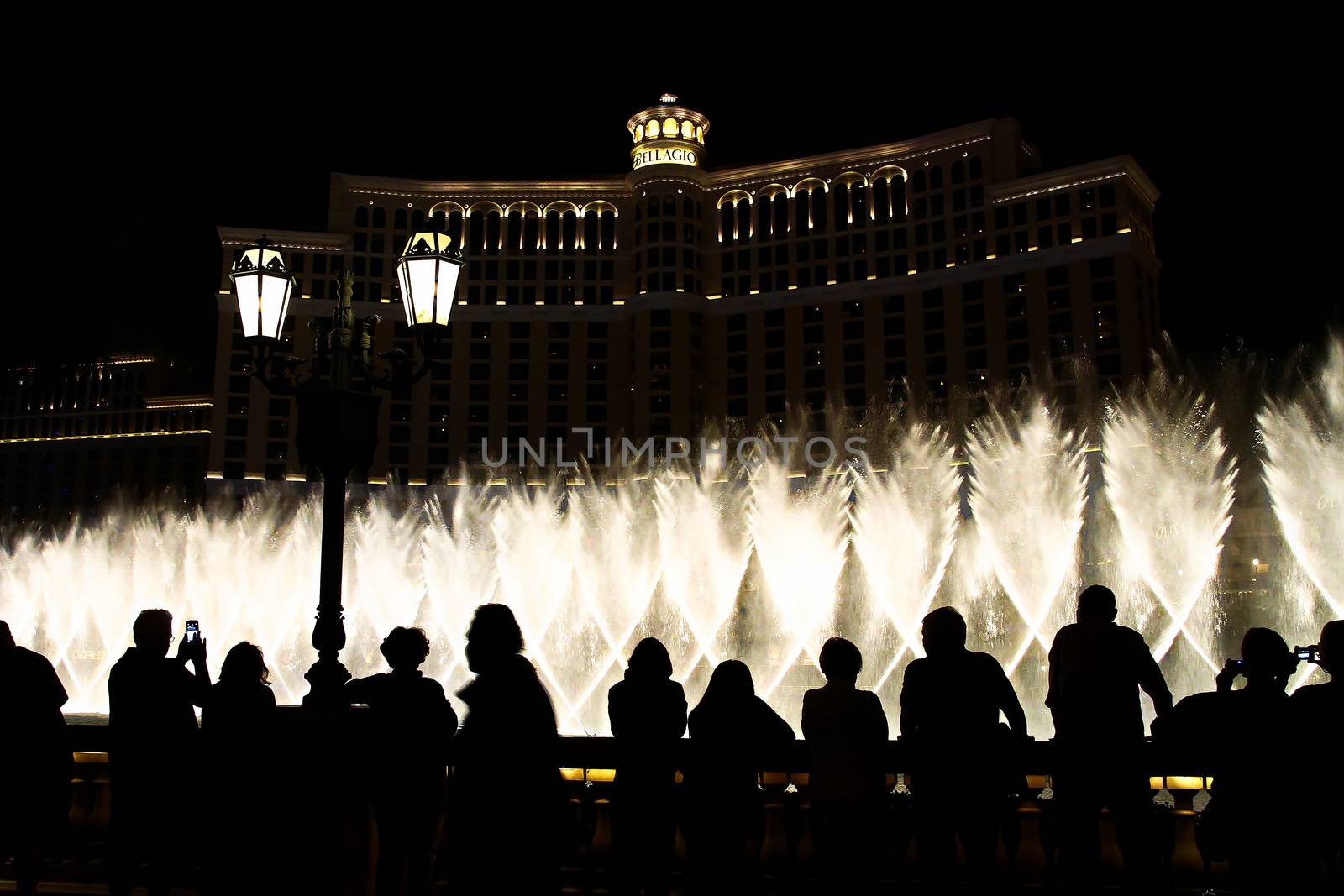 Night scene with silhouettes of people admiring the Bellagio fountains spectacle at Las Vegas by USA-TARO