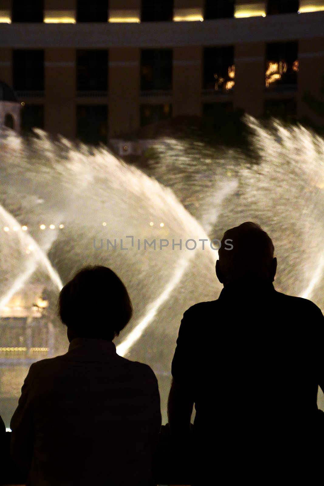 Night scene with silhouettes of people admiring the Bellagio fountains spectacle at Las Vegas by USA-TARO