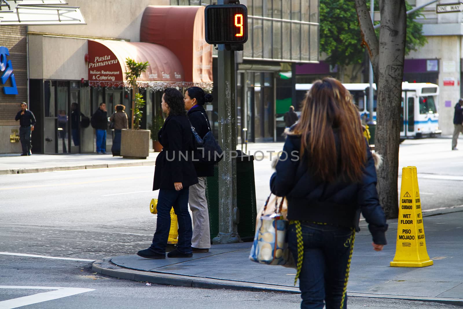 Los Angeles,CA/USA - Nov,03,2018 : Back view of young girls walking at an intersection and women waiting for a signal by USA-TARO