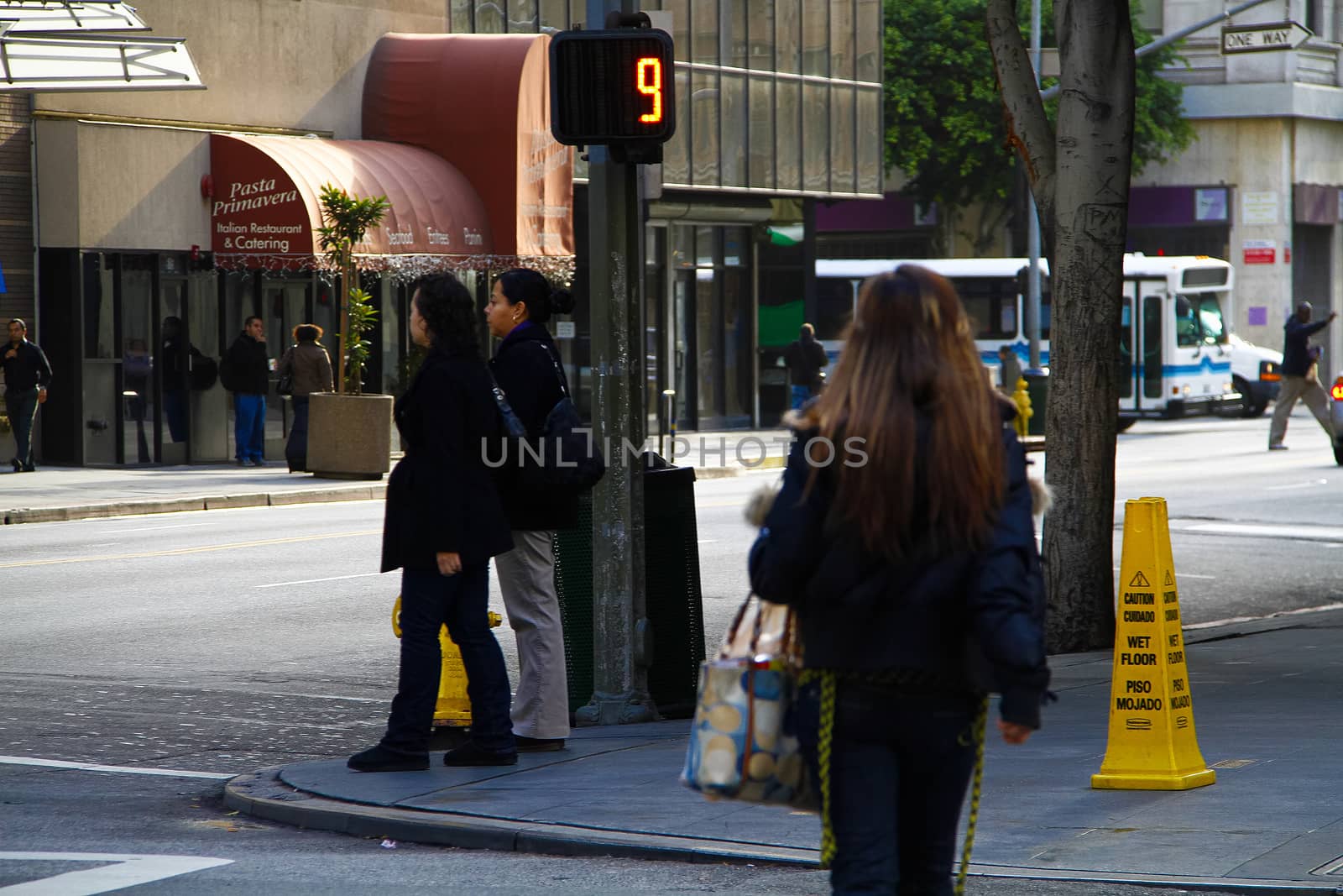 Los Angeles,CA/USA - Nov,03,2018 : Back view of young girls walking at an intersection and women waiting for a signal by USA-TARO