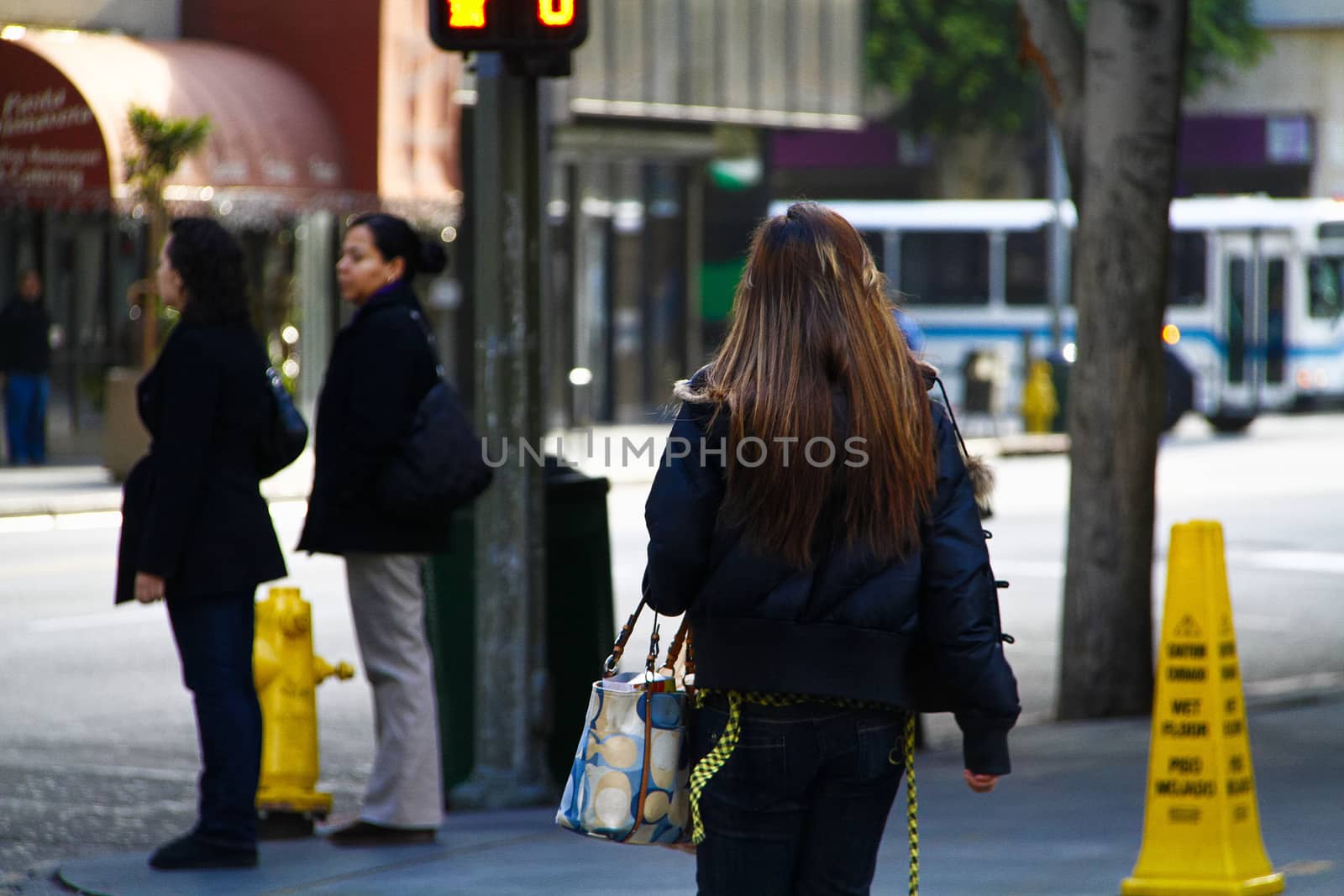 Los Angeles,CA/USA - Nov,03,2018 : Back view of young girls walking at an intersection and women waiting for a signal by USA-TARO