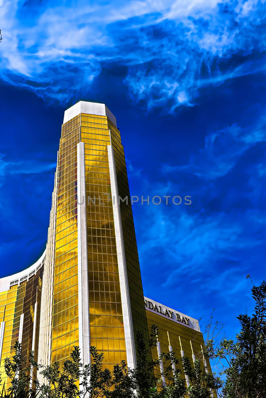 Las Vegas, NV/USA - Sep 15, 2018; Enormous Mandalay Bay Hotel Resort and Casino Las Vegas with beautifully landscaped entrance to modern architectural gold glass facade of building.