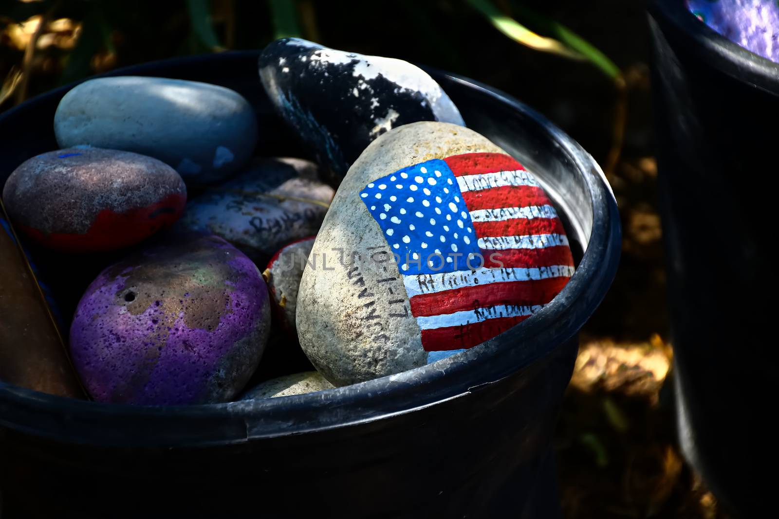 rock painted with the American Flag.American flag painted on a gray stone.Close-up of rock with American flag painted.