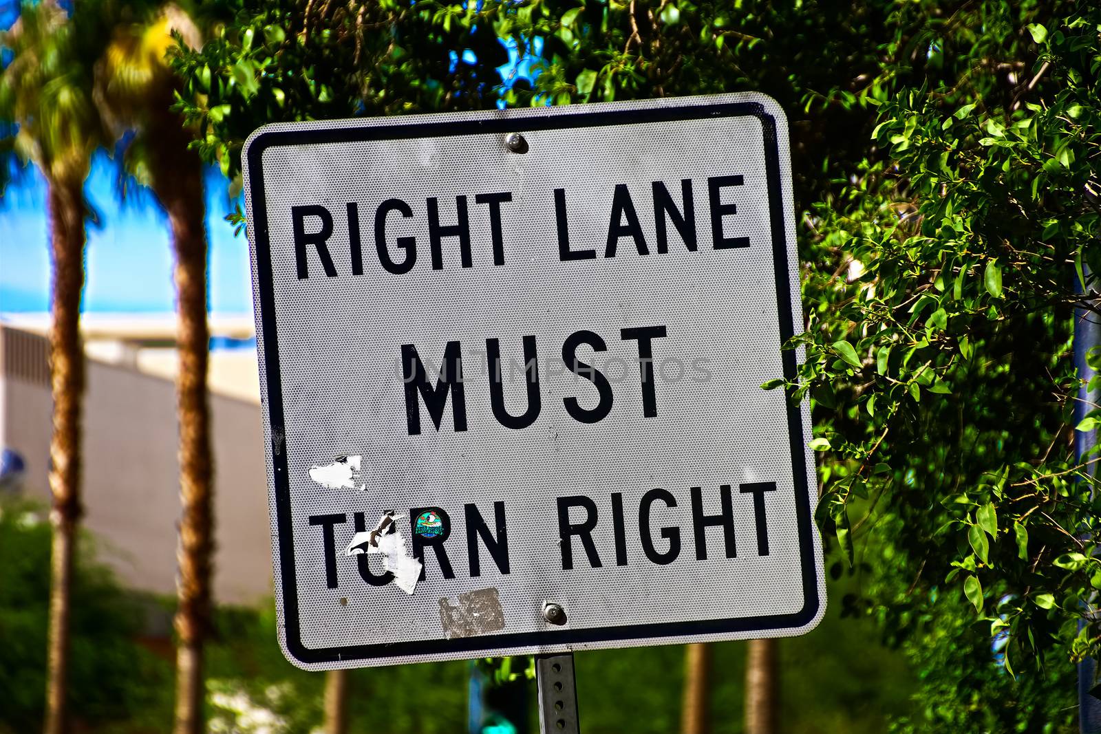 Sign of Right lane must turn right.Close up on a "Right Lane Must Turn Right" at an intersection, in a transportation background.Signpost in public street, "Right Lane Must Turn Right"