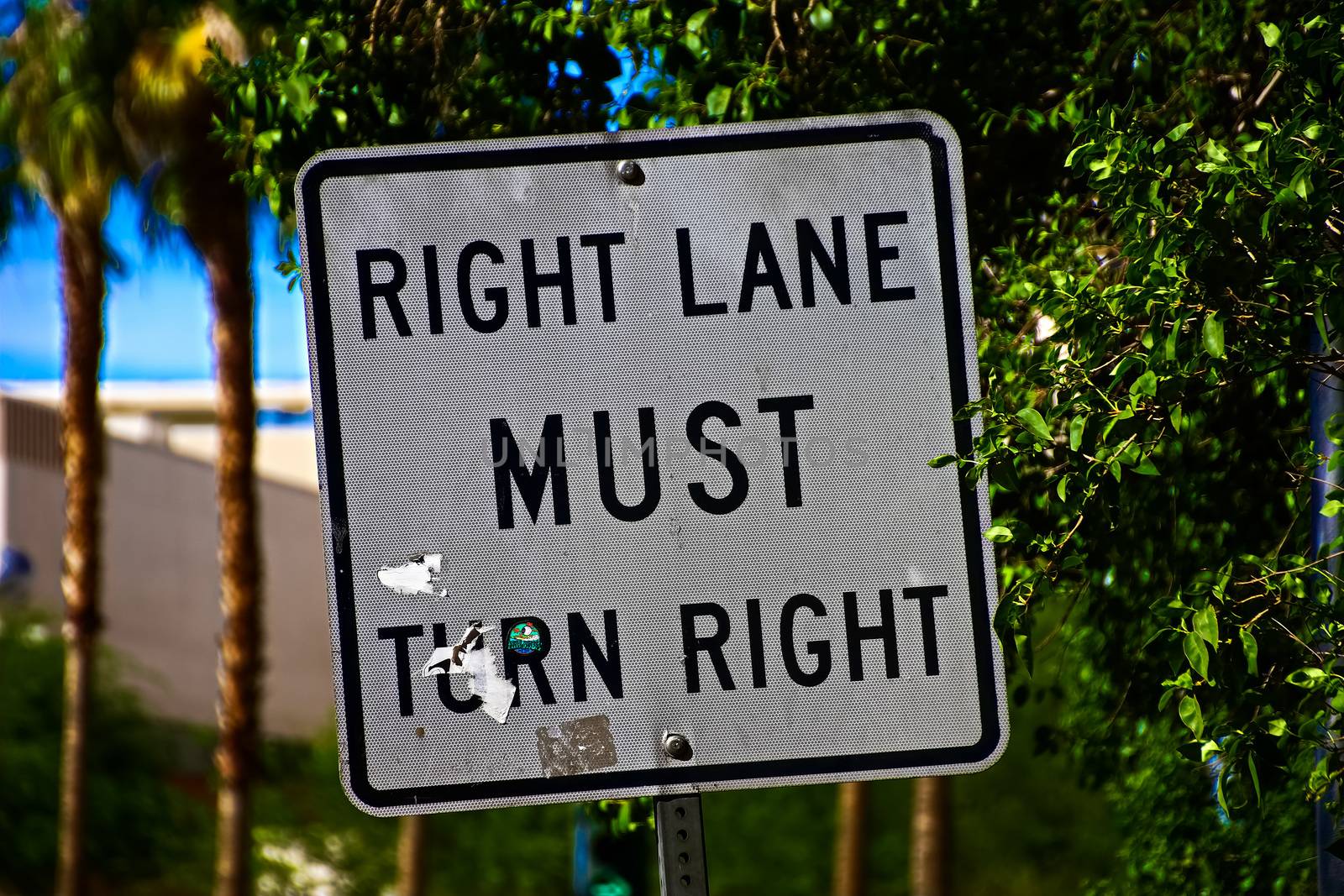 Sign of Right lane must turn right.Close up on a "Right Lane Must Turn Right" at an intersection, in a transportation background.Signpost in public street, "Right Lane Must Turn Right"