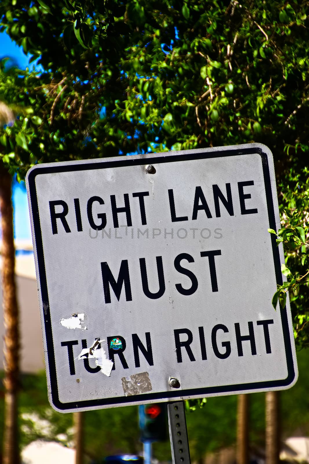 Sign of Right lane must turn right.Close up on a "Right Lane Must Turn Right" at an intersection, in a transportation background.Signpost in public street, "Right Lane Must Turn Right"