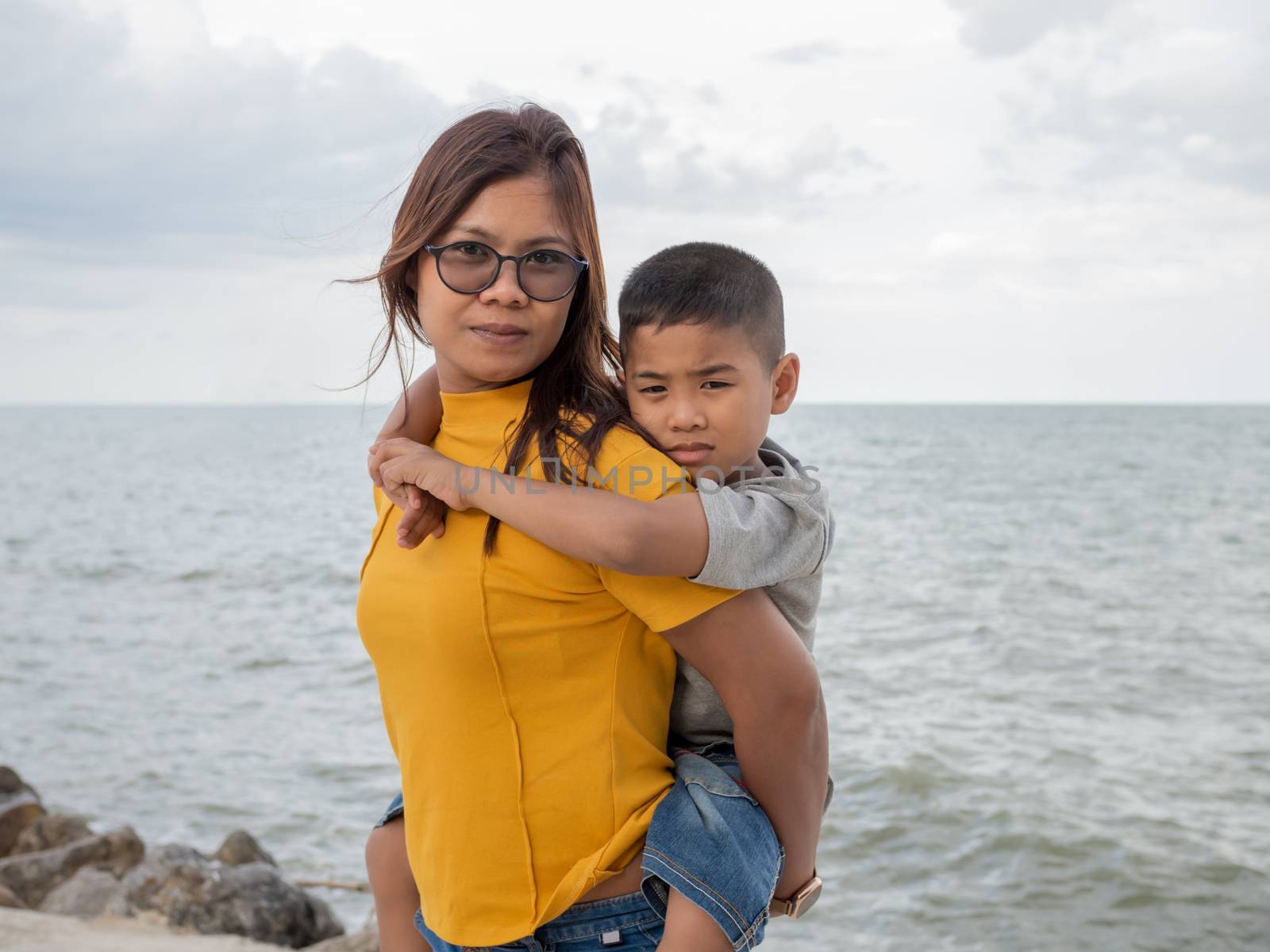 Portrait of mother and son on a sea background. by Unimages2527